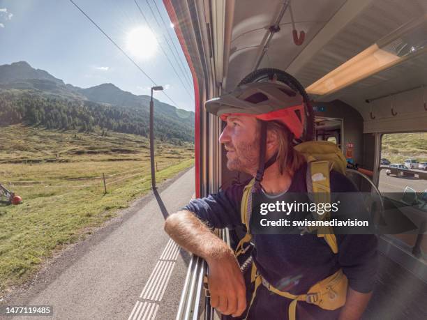 mountain biker on swiss train getting a ride up the mountain - passenger train stockfoto's en -beelden