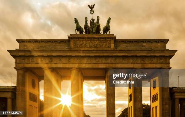 brandenburg gate at sunset (berlin, germany) - quadriga statue brandenburg gate stock-fotos und bilder