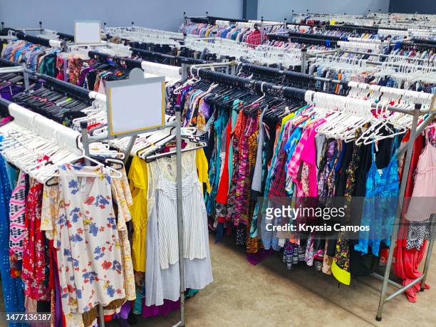 second hand clothes for sale at thrift store - clothes hanging on rack at store for sale foto e immagini stock