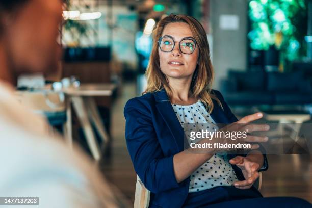 business woman talking to a colleague - body language at work stockfoto's en -beelden
