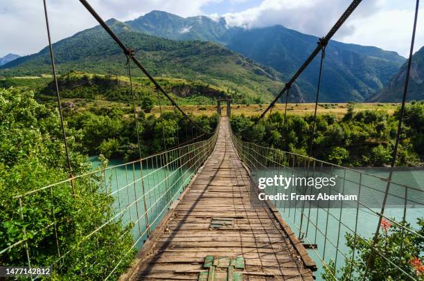 suspension bridge across vjosa river, albania - albania adventure stock pictures, royalty-free photos & images
