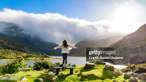 vista aérea de gap of dunloe, condado de kerry, irlanda, mujer observando el lago desde el punto de vista, siendo libre en la naturaleza, mujer fuerte en la naturaleza, mujer saludando a la naturaleza, foto cinematográfica de la naturaleza, relajación m - anillo de kerry fotografías e imágenes de stock