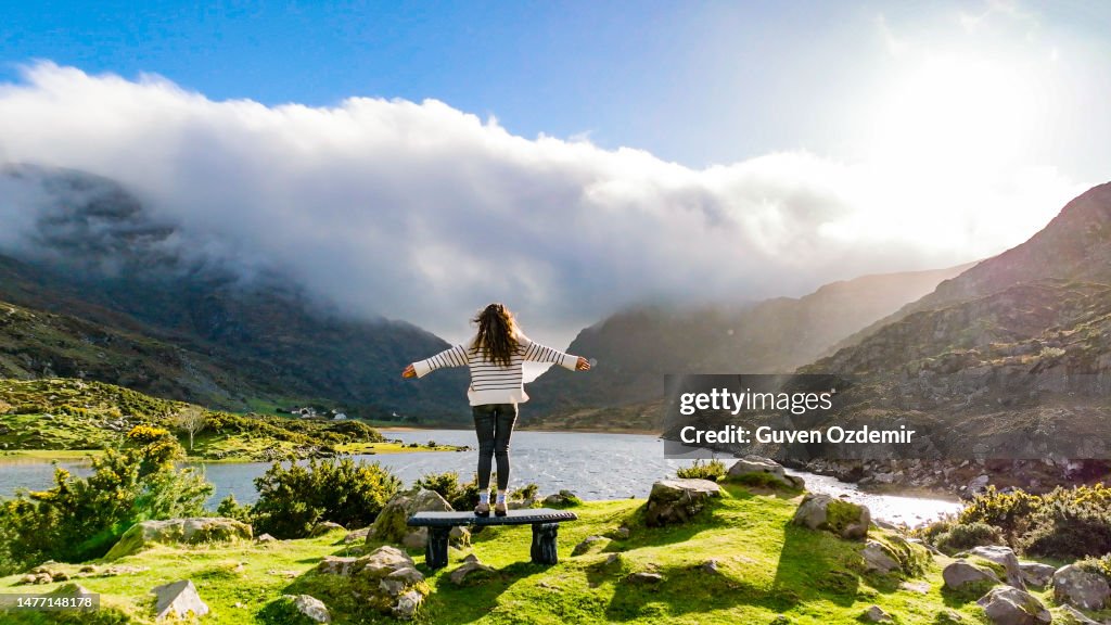 Aerial view of Gap of Dunloe, County Kerry, Ireland, woman watching lake from view point, being free in nature, strong woman in nature, woman saluting nature, cinematic nature photo, relaxation meditation nature, woman relaxing in nature