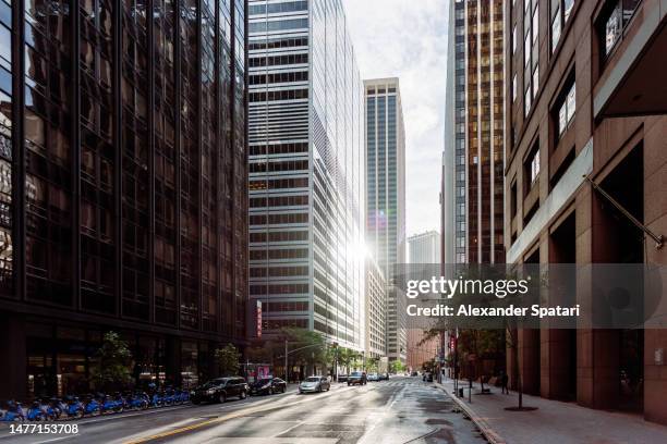 sun reflecting in glass skyscrapers in manhattan financial district, new york, usa - calle vacía fotografías e imágenes de stock
