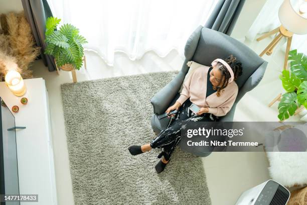 watching tv can help you boosts personality development and relieve stress. high-angle view of african american woman enjoying her favorite reality tv show at her home. - results show stockfoto's en -beelden
