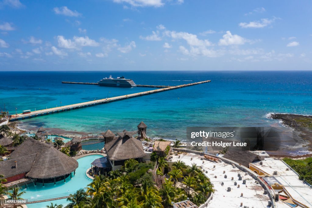 Aerial of New Mahahual shopping and entertainment complex with expedition cruise ship World Voyager (nicko cruises) at pier