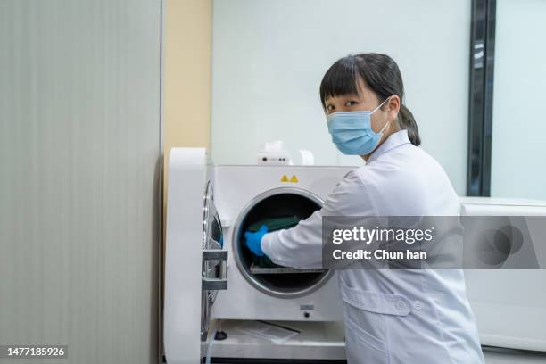 une femme dentiste organise des instruments médicaux - se frotter les mains photos et images de collection