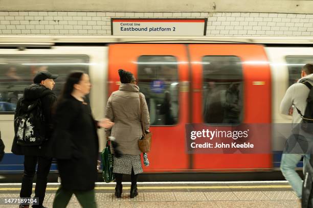 Commuters wait on the platform as a Central Line tube train arrives at Chancery Lane London Transport Tube Station on March 23, 2023 in London,...