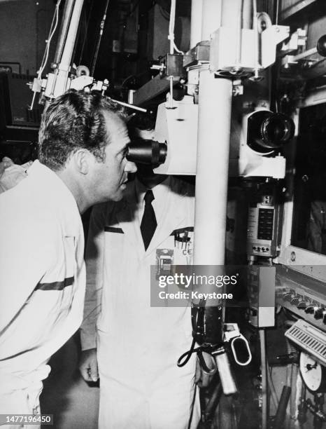 Spanish Royal Juan Carlos, Prince of Spain peers through a microscope at CEA Saclay, headquarters of the French Alternative Energies and Atomic...