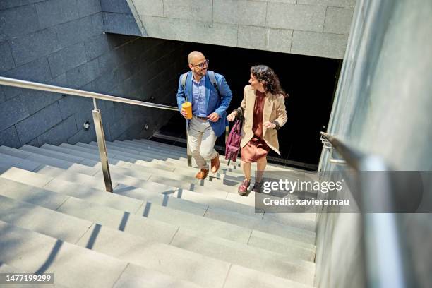 smiling business partners walking up staircase - moving up stock pictures, royalty-free photos & images