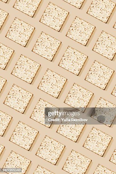 jewish cracker / passover (pessach) matzah on the beige background - passover symbols stock pictures, royalty-free photos & images