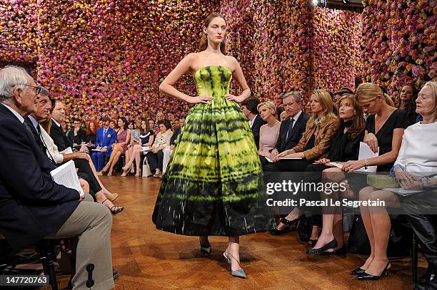 Princess Charlene of Monaco, Bernard Arnault, Delphine Arnault, Isabelle Huppert and guests watch a model as she walks the runway during the...