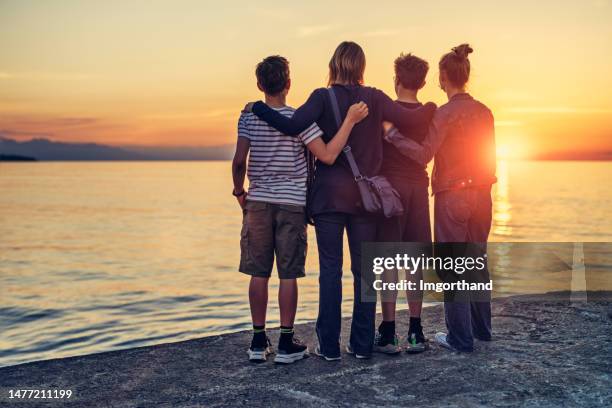 familie genießt sonnenuntergang am meer in der schönen italienischen stadt cefalu auf sizilien - boys sunset stock-fotos und bilder