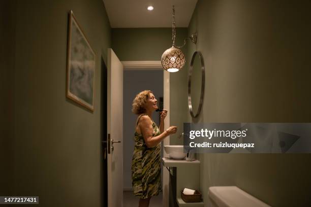 senior female putting on makeup - powder room stock pictures, royalty-free photos & images