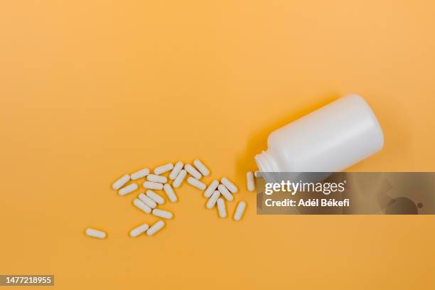 vitamin pills on yellow background - 鎂 個照片及圖片檔