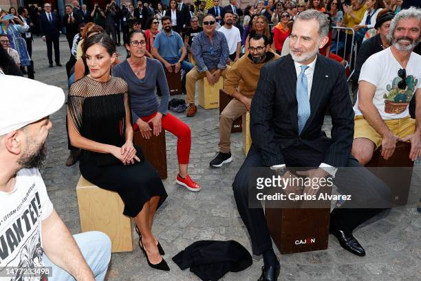 Queen Letizia of Spain is looking at King Felipe VI of Spain, who plays the traditional flamenco music box, on March 27, 2023 in Cadiz, Spain.