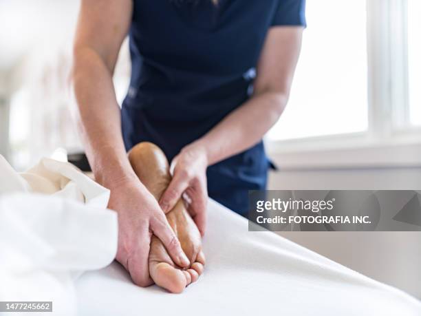 manos de terapeuta de masaje femenino tratando a paciente femenina - pressure point fotografías e imágenes de stock