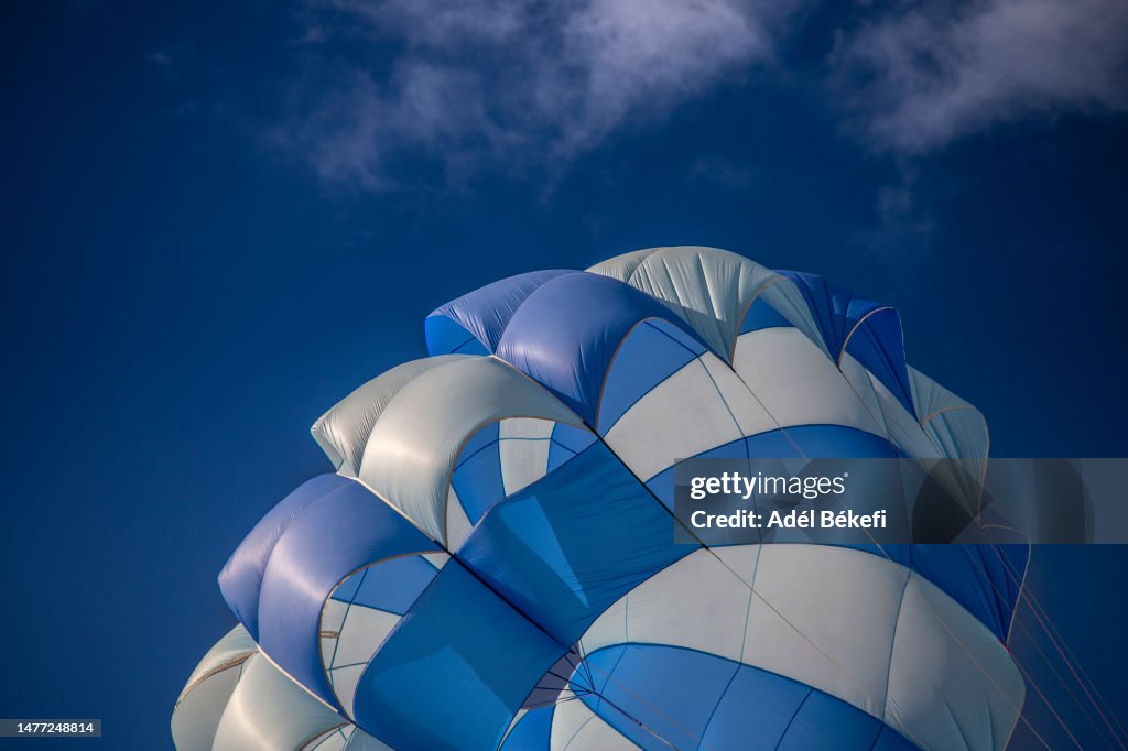 Low Angle View Of Blue and white Parachute Against Sky