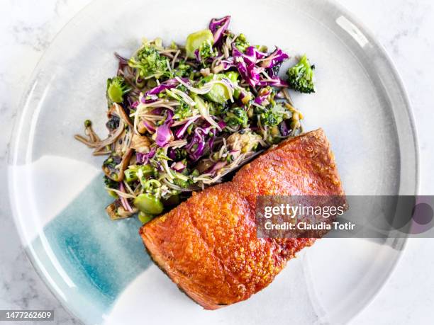 plate of fried salmon with fresh salad on white background - gebackener lachs stock-fotos und bilder