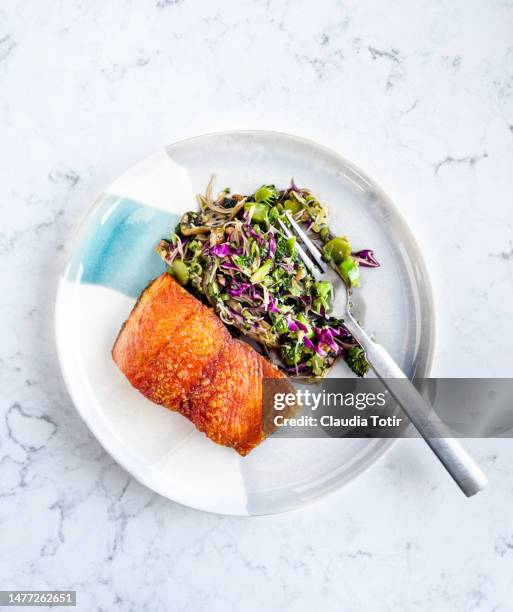 plate of fried salmon with fresh salad on white background - geroosterde zalm stockfoto's en -beelden