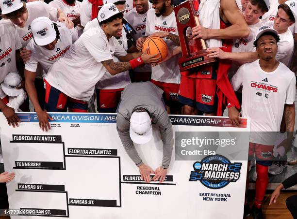 Head coach Dusty May of the Florida Atlantic Owls puts their team name on the bracket after defeating the Kansas State Wildcats 79-76 in the Elite...