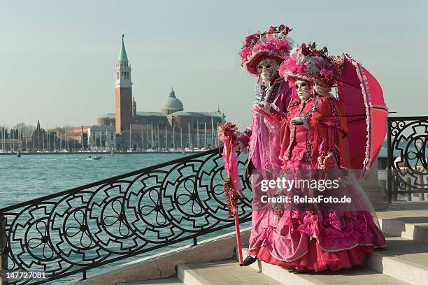 zwei masken auf brücke zum karneval in venedig (xxxl - venedig stock-fotos und bilder