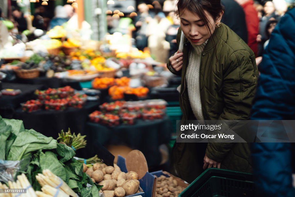 Young Asian woman shopping fruits and vegetables in local farmers market