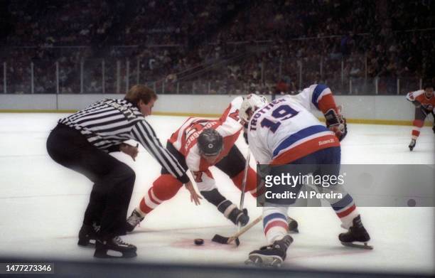 Right Wing Paul Holmgren of the Philadelphia Flyers is beaten in a faceoff with Center Bryan Trottier of the New York Islanders in the game between...