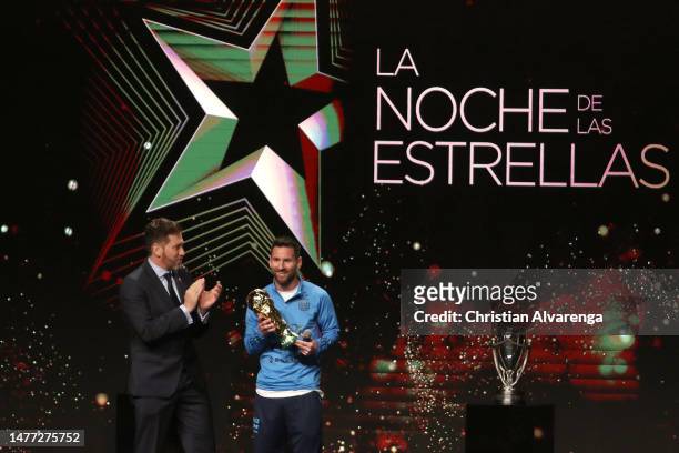 Lionel Messi of Argentina receives the FIFA World Cup trophy from Alejandro Dominguez President of CONMEBOL during an event organized by CONMEBOL at...