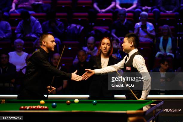 Ding Junhui of China shakes hands with Mark Allen of Northern Ireland in the quarter-final match on day 1 of Tour Championship Snooker 2023 at the...