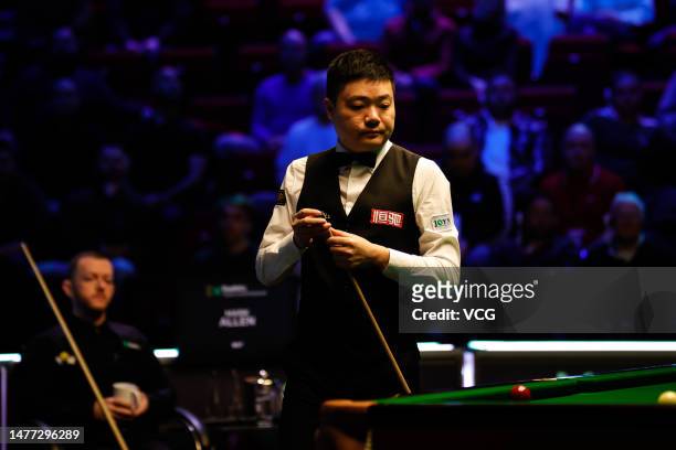 Ding Junhui of China chalks the cue in the quarter-final match against Mark Allen of Northern Ireland on day 1 of Tour Championship Snooker 2023 at...