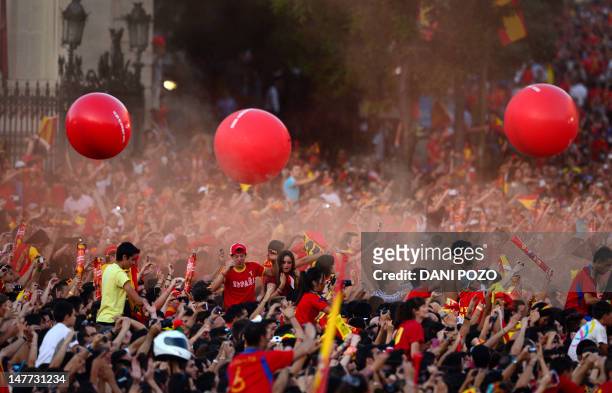 Supporters of the Spanish national football team celebrate on July 2, 2012 on Cibeles Square in Madrid, a day after it won the final match of the...