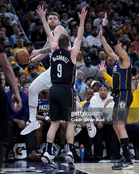 Luka Doncic of the Dallas Mavericks passes the ball while being guarded by T.J. McConnell and Andrew Nembhard of the Indiana Pacers in the third...