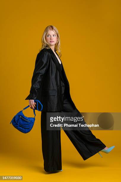 fashionable woman wearing black suit - position physique photos et images de collection