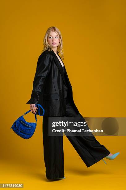 fashionable woman wearing black suit - blue purse stock pictures, royalty-free photos & images