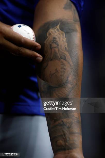 Carlos Hernandez of the Kansas City Royals shows a tattoo while in the dugout during the game against the Texas Rangers at Globe Life Field on March...