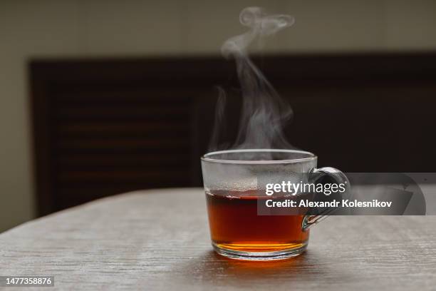 glass cup with hot tea on table. - tea cup photos et images de collection