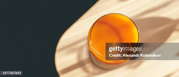 freshly squeezed apricot juice in a glass jar on table with shadow sunlights. directly above with copy space. banner for web site and design - smoothie sparse stock pictures, royalty-free photos & images