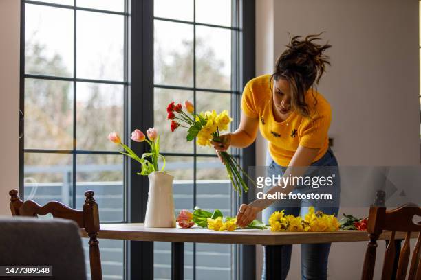 young woman arranging beautiful spring flowers in a bouquet - tulips and daffodils stock pictures, royalty-free photos & images