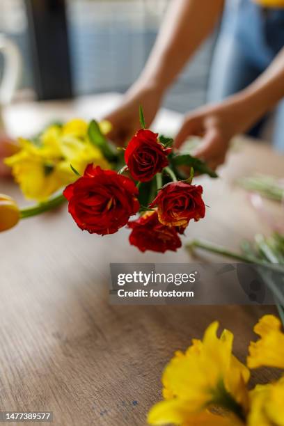 young woman arranging beautiful spring flowers in a bouquet - ikebana arrangement stock pictures, royalty-free photos & images