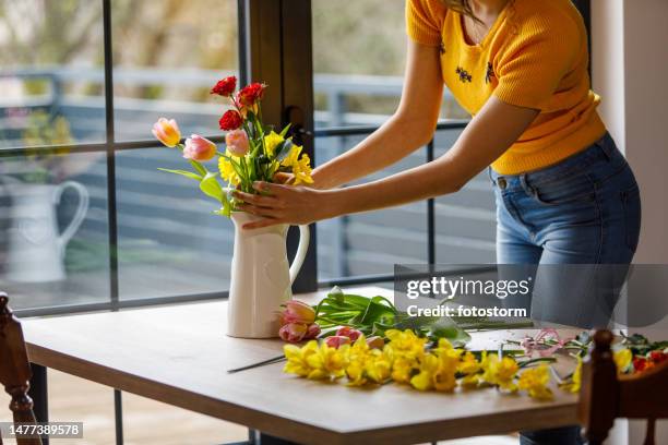 young woman arranging flowers and putting them in a vase - vas bildbanksfoton och bilder