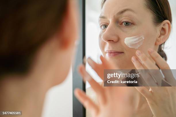 woman applying cream mask on face - showus fitness stock pictures, royalty-free photos & images