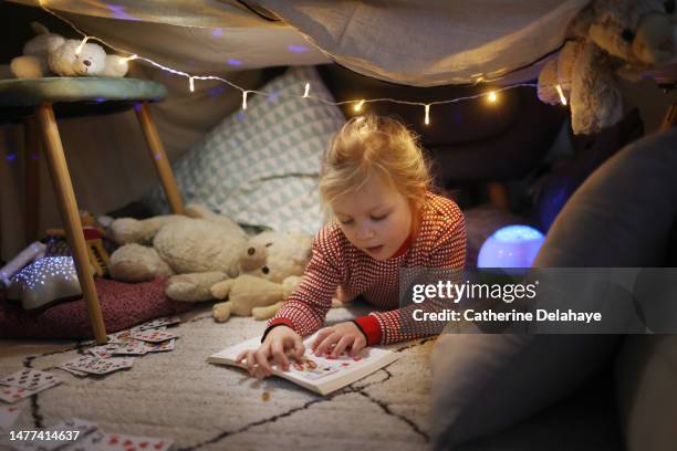 a little girl playing in a homemade illuminated hut, at home - child in space suit stock pictures, royalty-free photos & images