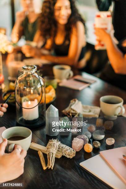 sage and variety of crystals arranged on dining table at retreat center - spirituality crystals stock pictures, royalty-free photos & images