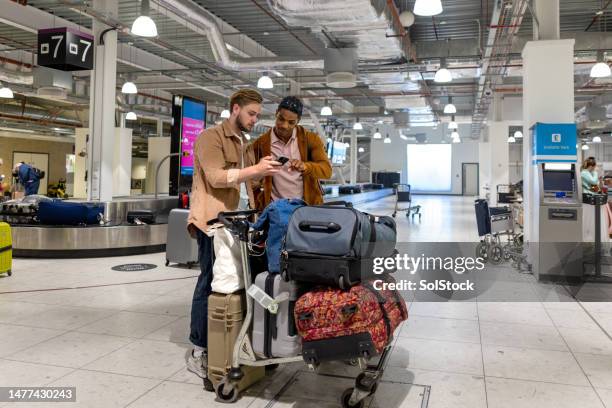 travellers with their luggage - luggage trolley stockfoto's en -beelden