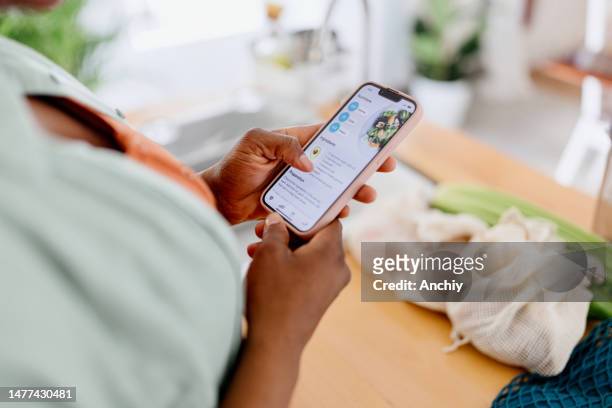 close up of a woman holding smartphone with health app on the screen - virtual lunch stock pictures, royalty-free photos & images