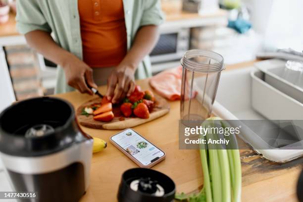 woman slicing strawberries on a chopping board - meal plan stock pictures, royalty-free photos & images