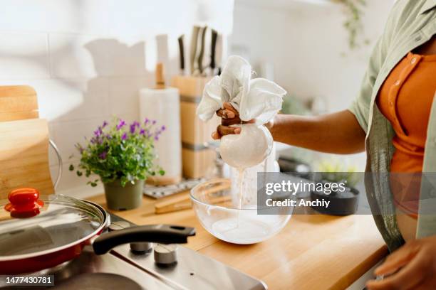 woman preparing homemade almond milk - almond meal stock pictures, royalty-free photos & images