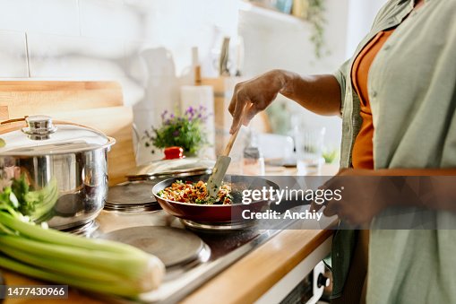 Woman preparing quinoa vegetable mix cooked in a frying pan Woman preparing quinoa vegetable mix cooked in a frying pan