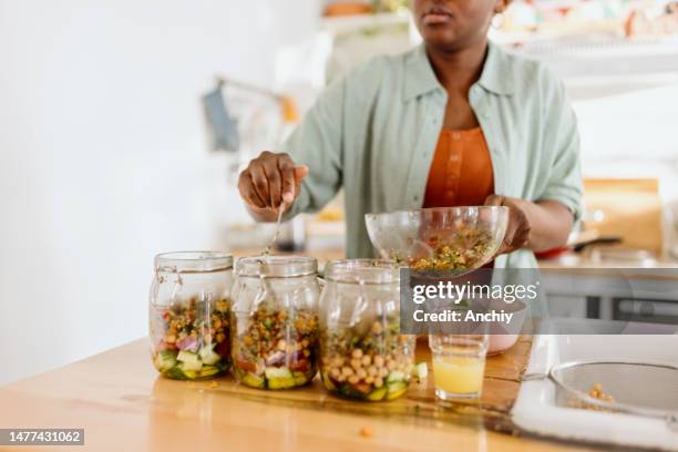 femme préparant une salade savoureuse dans un bocal - préparation des aliments photos et images de collection